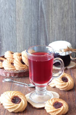 Ahşap bir masa üzerinde reçelli Kahvaltı, kırmızı çay çaydanlık ve bardak ve çerezleri için tablo hizmet