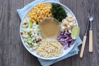 Mısır, elma, kırmızı soğan, peynir ve dereotu ile rustik tabloda lezzetli yaz makarna salatası