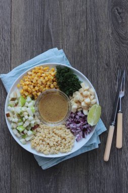 Mısır, elma, kırmızı soğan, peynir ve dereotu ile rustik tabloda lezzetli yaz makarna salatası