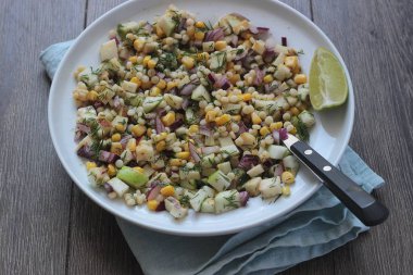 Mısır, elma, kırmızı soğan, peynir ve dereotu ile rustik tabloda lezzetli yaz makarna salatası