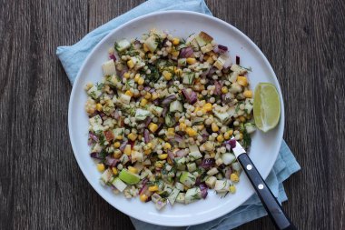 Mısır, elma, kırmızı soğan, peynir ve dereotu ile rustik tabloda lezzetli yaz makarna salatası