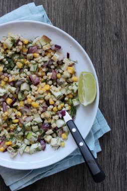 Mısır, elma, kırmızı soğan, peynir ve dereotu ile rustik tabloda lezzetli yaz makarna salatası