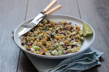 Mısır, elma, kırmızı soğan, peynir ve dereotu ile rustik tabloda lezzetli yaz makarna salatası