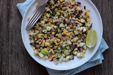 Mısır, elma, kırmızı soğan, peynir ve dereotu ile rustik tabloda lezzetli yaz makarna salatası