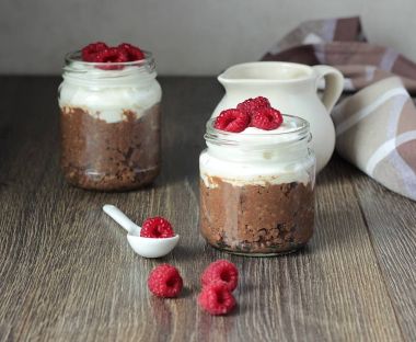 Darı lapası çikolata, krema ve ahududu rustik arka plan ile. Sağlıklı kahvaltı.