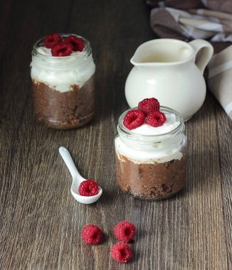 Darı lapası çikolata, krema ve ahududu rustik arka plan ile. Sağlıklı kahvaltı.