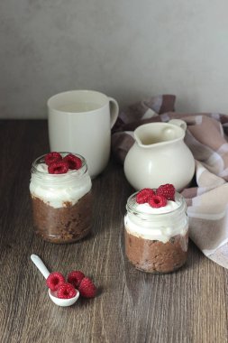 Darı lapası çikolata, krema ve ahududu rustik arka plan ile. Sağlıklı kahvaltı.