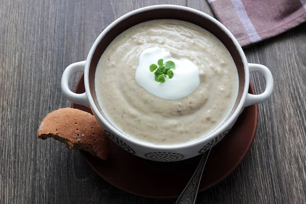 Lentilha e sopa de creme de ervilha com creme, ervas e em um fundo de madeira . — Fotografia de Stock