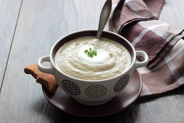 Lentilha e sopa de creme de ervilha com creme, ervas e em um fundo de madeira . — Fotografia de Stock