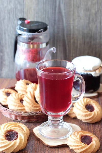 Ahşap bir masa üzerinde reçelli Kahvaltı, kırmızı çay çaydanlık ve bardak ve çerezleri için tablo hizmet