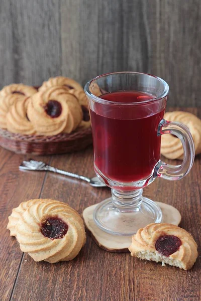 Ahşap bir masa üzerinde reçelli Kahvaltı, kırmızı çay çaydanlık ve bardak ve çerezleri için tablo hizmet