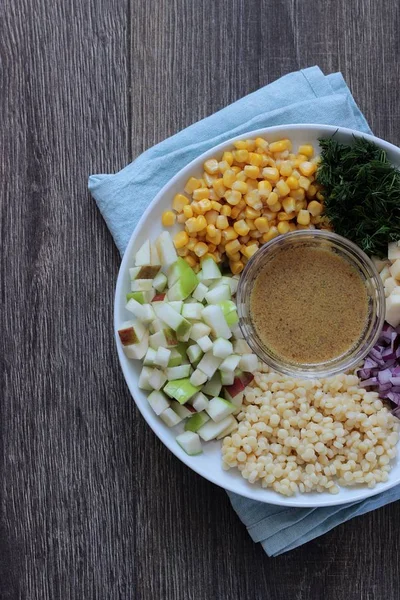 Mısır, elma, kırmızı soğan, peynir ve dereotu ile rustik tabloda lezzetli yaz makarna salatası