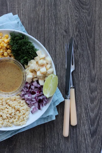 Mısır, elma, kırmızı soğan, peynir ve dereotu ile rustik tabloda lezzetli yaz makarna salatası