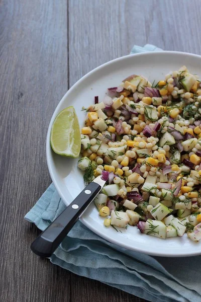 Mısır, elma, kırmızı soğan, peynir ve dereotu ile rustik tabloda lezzetli yaz makarna salatası