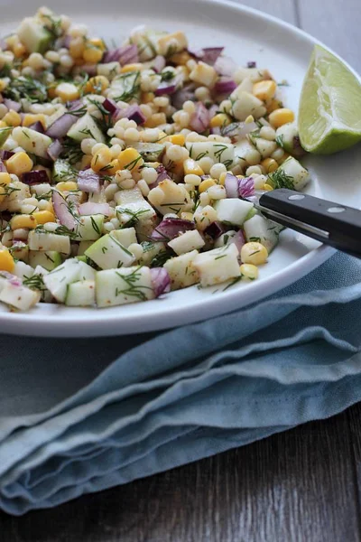 Mısır, elma, kırmızı soğan, peynir ve dereotu ile rustik tabloda lezzetli yaz makarna salatası