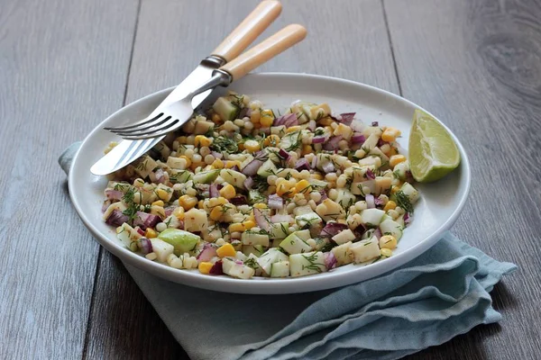 Mısır, elma, kırmızı soğan, peynir ve dereotu ile rustik tabloda lezzetli yaz makarna salatası