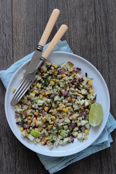 Mısır, elma, kırmızı soğan, peynir ve dereotu ile rustik tabloda lezzetli yaz makarna salatası