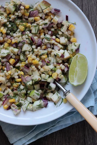 Mısır, elma, kırmızı soğan, peynir ve dereotu ile rustik tabloda lezzetli yaz makarna salatası