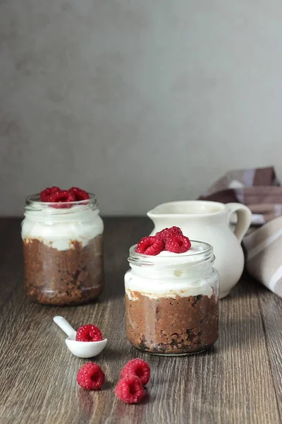 Darı lapası çikolata, krema ve ahududu rustik arka plan ile. Sağlıklı kahvaltı.