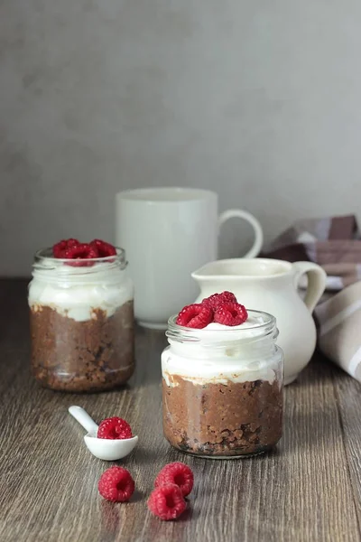 Mingau de milho com chocolate, creme e framboesas no fundo rústico. Café da manhã saudável . — Fotografia de Stock