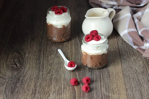 Darı lapası çikolata, krema ve ahududu rustik arka plan ile. Sağlıklı kahvaltı.