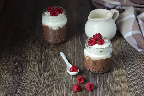 Darı lapası çikolata, krema ve ahududu rustik arka plan ile. Sağlıklı kahvaltı.