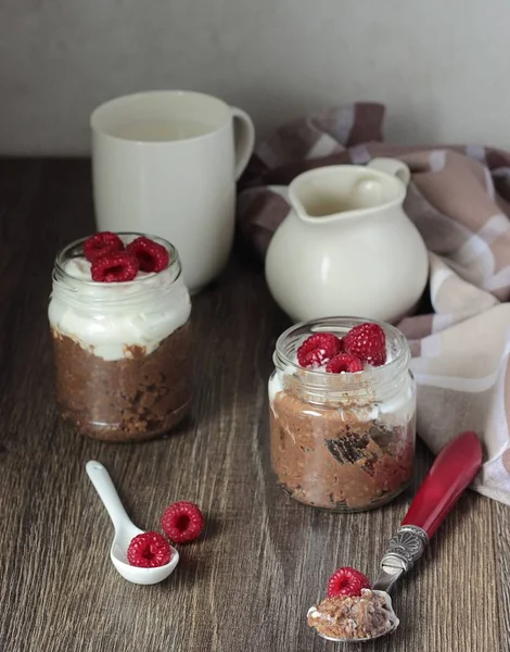 Darı lapası çikolata, krema ve ahududu rustik arka plan ile. Sağlıklı kahvaltı.