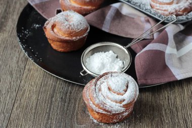 Clay tepsiye (kruvasan ve muffin gibi) modern ev yapımı hamur işleri cruffins pudra şekeri ile hizmet.