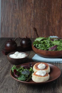 Ekşi krema ve yeşil salata ile patates kızarmış vejetaryen pirzola yapılmış