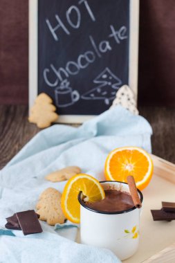 Sıcak çikolata veya kakao içki portakal ve tarçın sopayla gingerbread çerezleri ve çikolata parçaları ile servis.