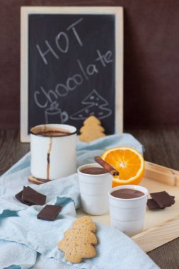 Sıcak çikolata veya kakao içki portakal ve tarçın sopayla gingerbread çerezleri ve çikolata parçaları ile servis.