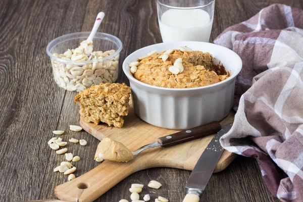 Peanut butter oatmeal cake with milk decorated with peanuts.