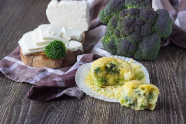 Ev yapımı kekler brokoli ve ahşap zemin üzerine peynir ile. Sağlıklı snack.