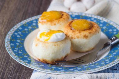 Ekşi krema ve portakal reçeli ile bir plaka üzerinde süzme peynir krep. Syrniki. Geleneksel Rus Mutfağı