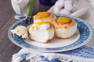 Ekşi krema ve portakal reçeli ile bir plaka üzerinde süzme peynir krep. Syrniki. Geleneksel Rus Mutfağı