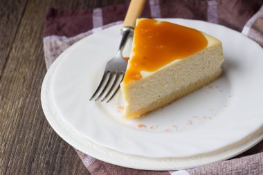 Beyaz tabakta tuzlu karamel soslu vanilyalı cheesecake (New York cheesecake) 