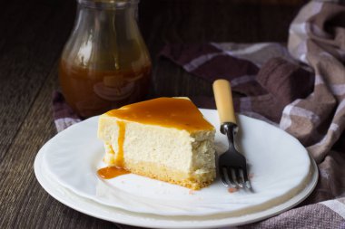 Beyaz tabakta tuzlu karamel soslu vanilyalı cheesecake (New York cheesecake) 