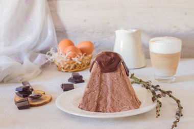 Paskalya çikolata kuark tatlı çikolata sır (ganashe) ve bir fincan kapuçino ışık gri arka plan üzerinde. Geleneksel Rus Ortodox paskalya tatlısı - Paskha.