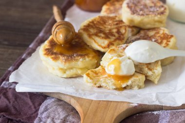 Ekşi krema ve ballı bir ahşap kesme tahtası üzerinde kızarmış Maya krep elma ile servis. Kahvaltı konsepti.