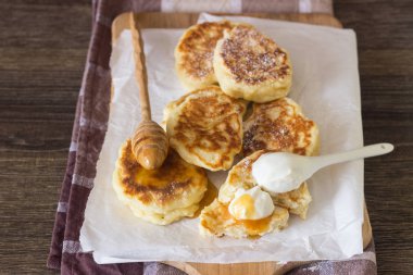 Ekşi krema ve ballı bir ahşap kesme tahtası üzerinde kızarmış Maya krep elma ile servis. Kahvaltı konsepti.