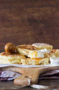 Ekşi krema ve ballı bir ahşap kesme tahtası üzerinde kızarmış Maya krep elma ile servis. Kahvaltı konsepti.