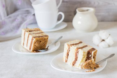 Ekşi krema bir beyaz plaka ve açık renkli çikolata ve beyaz katmanlarla ile şifon pasta dilimi