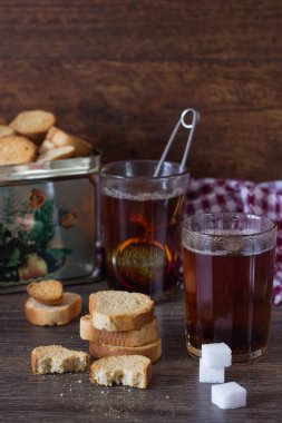 Siyah çay ile geleneksel İtalyan bisküvi ya da cantuccini ahşap masa üzerinde iki bardak.