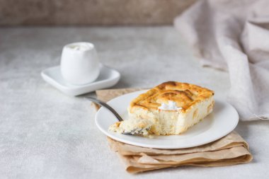 Süzme peynir güveç beyaz tabakta. Puding süzme peynir pişmiş.