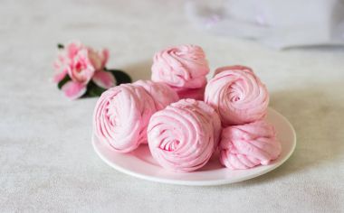 Güzel lezzetli tatlı. Bir beyaz plaka ve pembe çiçek pembe zephyr. Berry zephyr ışık gri arka plan üzerinde. 