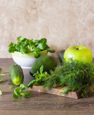 Taze yeşil sebze (avokado, salatalık, Mısır salata ve dereotu) ahşap arka plan üzerinde. Yeşil salata veya yeşil smoothie için malzemeler. Detoks, diyet veya sağlıklı gıda kavramı. Metin için yer. 