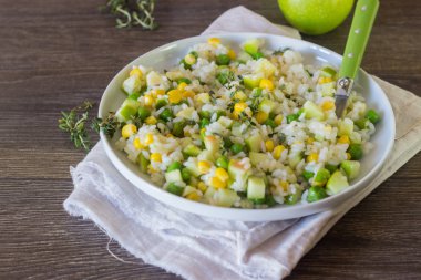 Pirinç salatası yeşil bezelye, Mısır ve apple beyaz tabakta kekik ile.