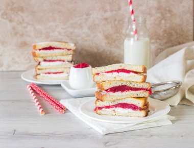 Yumurtalı ekmek krem peynir ve reçel bir beyaz plaka ve ışık arka plan ile. Krem peynir ve reçel ile lezzetli sandviç. 