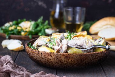 Elma ve elma suyuyla kavrulmuş tavuk butları koyu kahverengi ahşap bir masada. Sonbahar yemeği tarifi. Rahatlatıcı yemek..