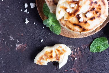 Tahta tabakta servis edilen soğan, nane ve peynir küçük düz ekmekler. Gozme - gevrek, altın rengi Türk ekmeği.